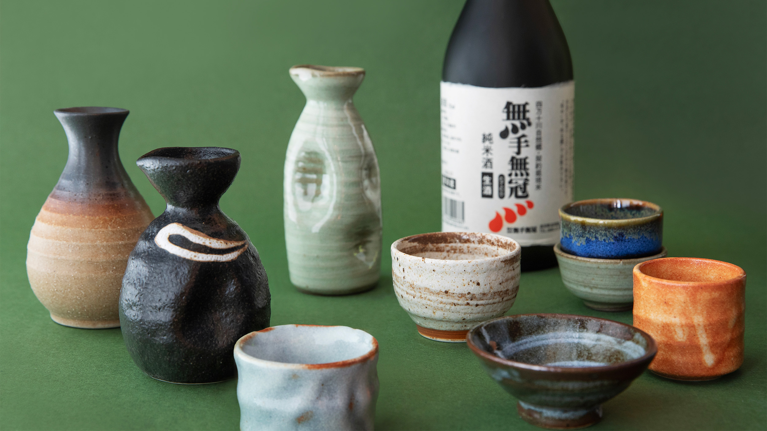 Various ceramic sake cups and bottles.